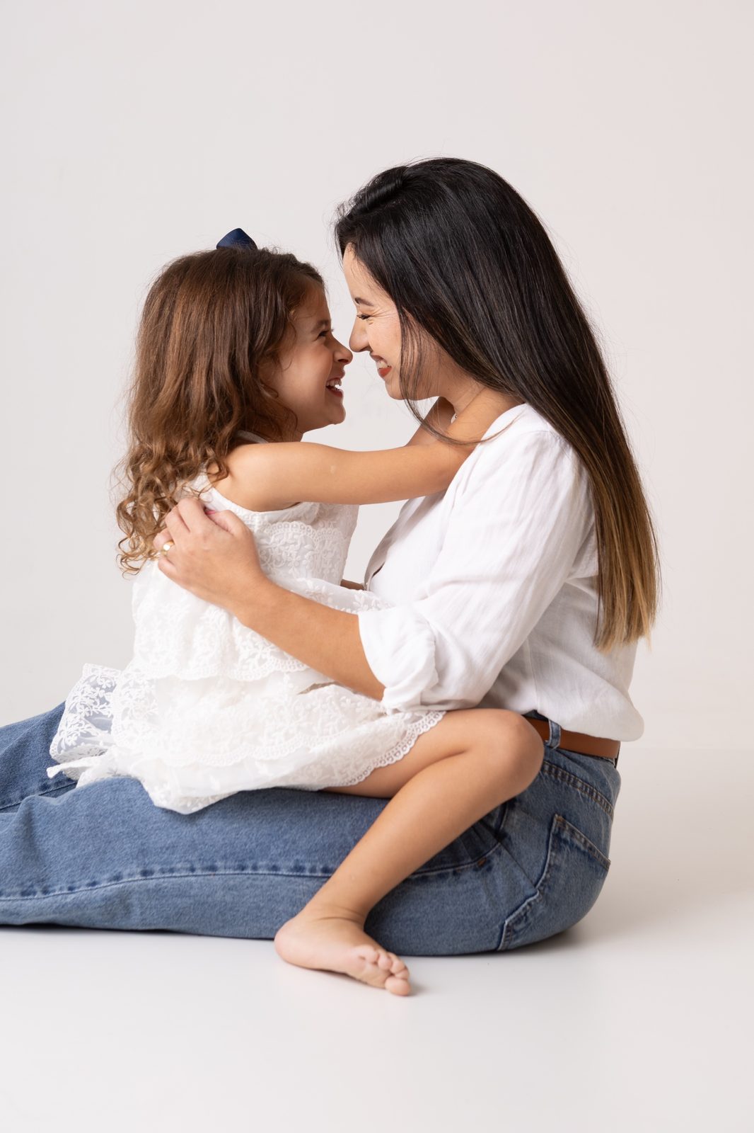 Mãe e filha se abraçando em fundo claro