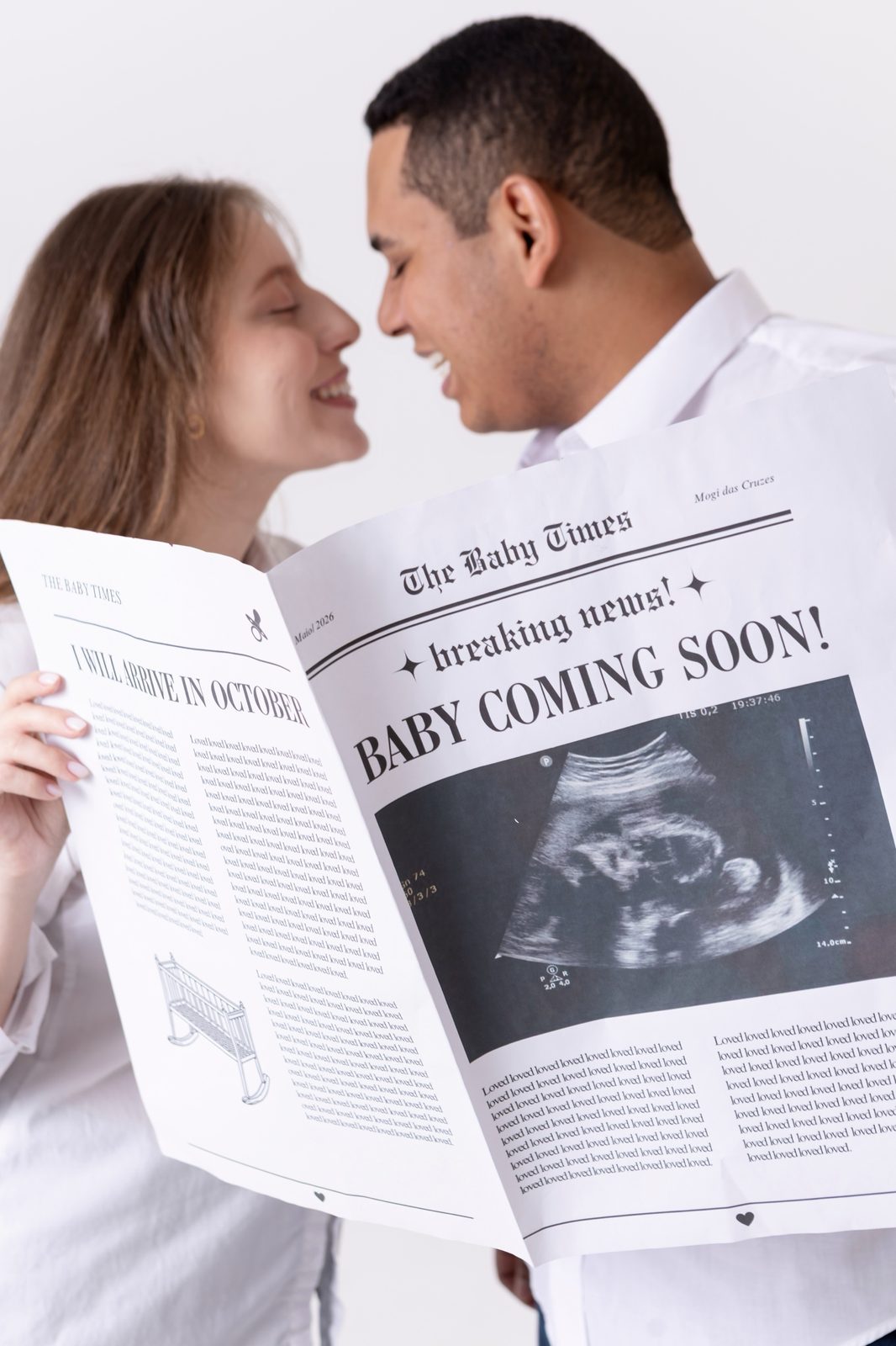 Casal anunciando a chegada do bebê com jornal personalizado